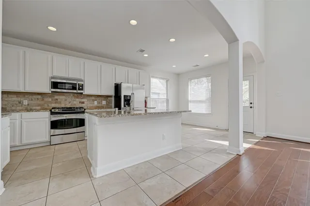 a kitchen with stainless steel appliances granite countertop a stove a sink and a refrigerator