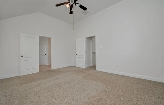 an empty room with chandelier fan