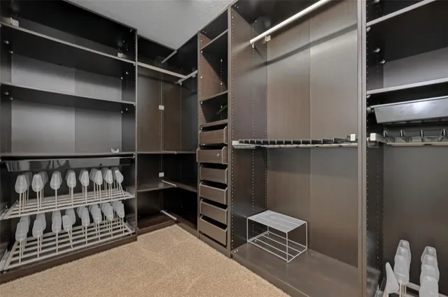 a view of walk in closet with empty racks