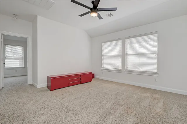 an empty room with windows and fan