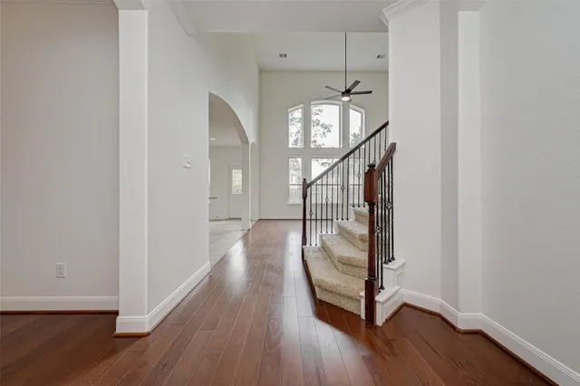 a view of a hallway with wooden floor and staircase