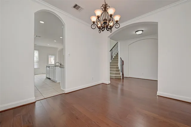 wooden floor in an empty room with a chandelier