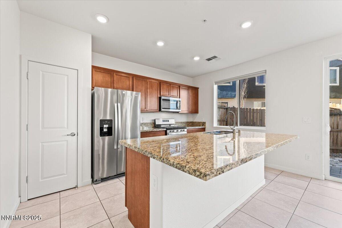 1048 Big Rock Loop Sun Valley, NV 89433 - Photo 3 of 25 a large kitchen with kitchen island granite countertop a refrigerator and a sink