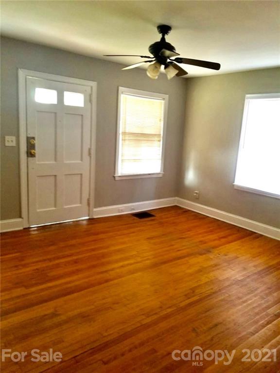 1135 Skyview Road Charlotte, NC 28208 - Photo 4 of 14 an empty room with wooden floor and windows