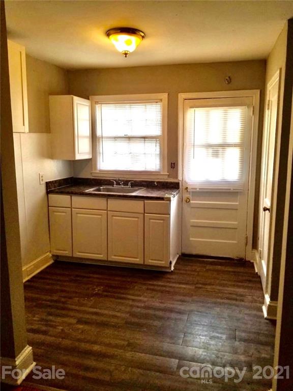 1135 Skyview Road Charlotte, NC 28208 - Photo 5 of 14 a view of a kitchen with a sink wooden cabinets and a window