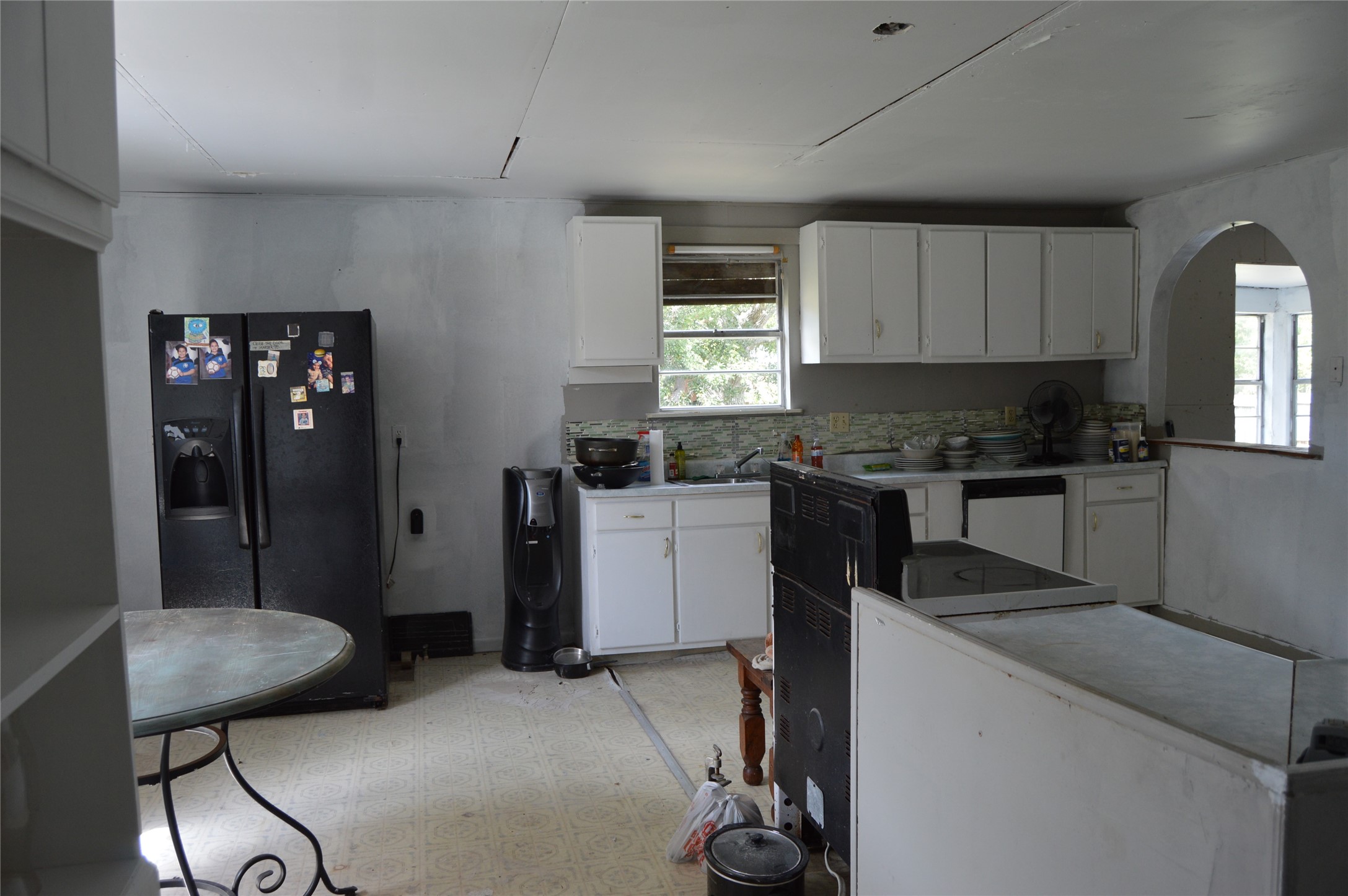 692 Cashscreek Road Palacios, TX 77465 - Photo 3 of 31 a kitchen with a refrigerator a stove top oven a sink a dining table and chairs