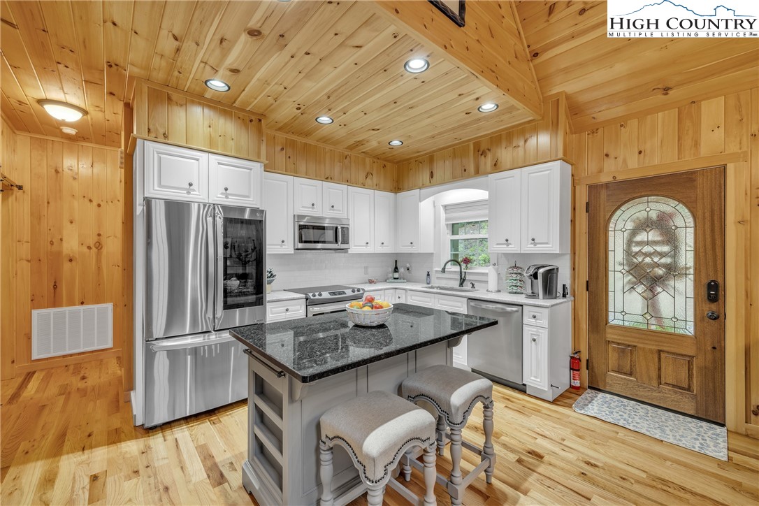 201 Eagles Nest Trail West Jefferson, NC 28694 - Photo 10 of 43 a kitchen with stainless steel appliances granite countertop a refrigerator a stove and a wooden floors