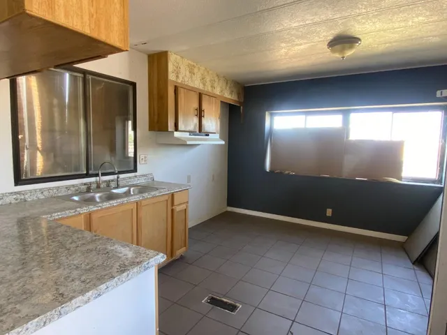 a view of a kitchen with kitchen island a sink a counter top and outdoor space