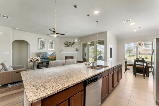 a large kitchen with kitchen island a large counter space dining table and stainless steel appliances