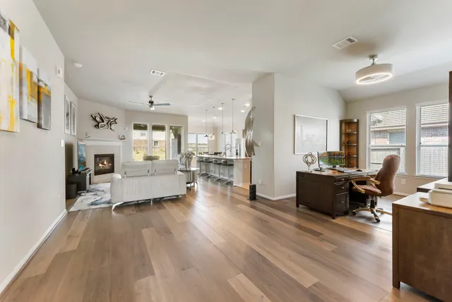 a living room with furniture and a wooden floor