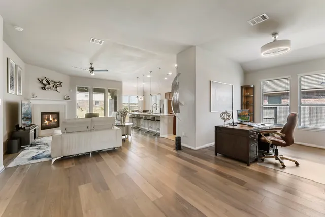 a living room with furniture wooden floor and a kitchen view