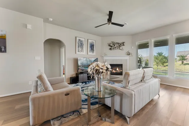a living room with fireplace furniture and a large window