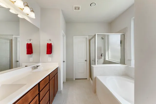 a bathroom with a tub sink and mirror