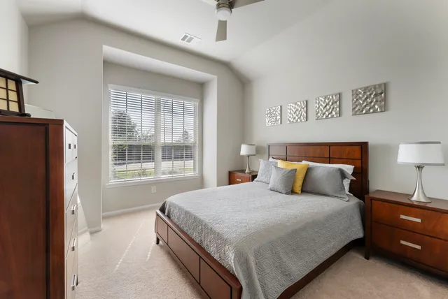 a bedroom with a bed and a lamp on table window