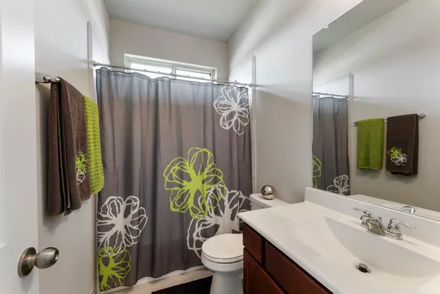 a bathroom with a sink mirror vanity and toilet