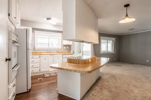 a living room with white cabinets and wooden floor