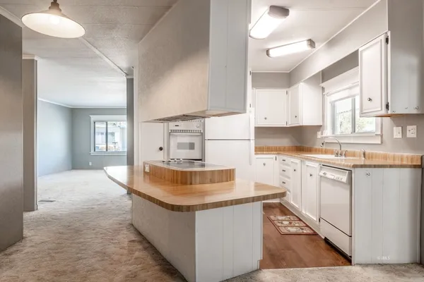 a kitchen with granite countertop a sink a stove and cabinets