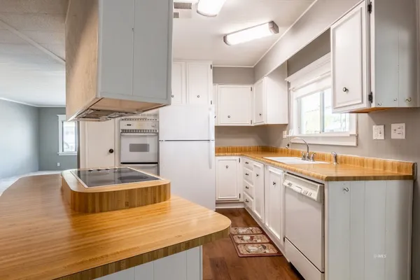 a living room with white cabinets and wooden floor