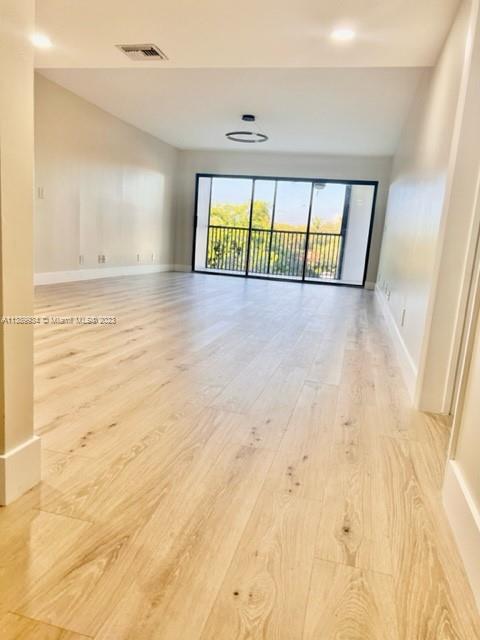 491 Racquet Club Road, Unit 312 Weston, FL 33326 - Photo 1 of 7 wooden floor in an empty room with a window