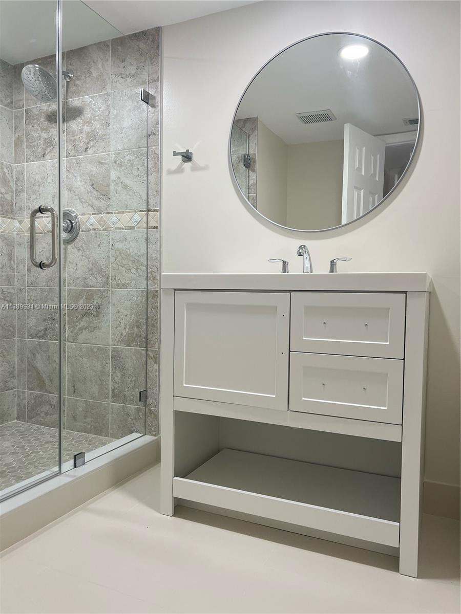 491 Racquet Club Road, Unit 312 Weston, FL 33326 - Photo 6 of 7 a bathroom with a mirror and a shower
