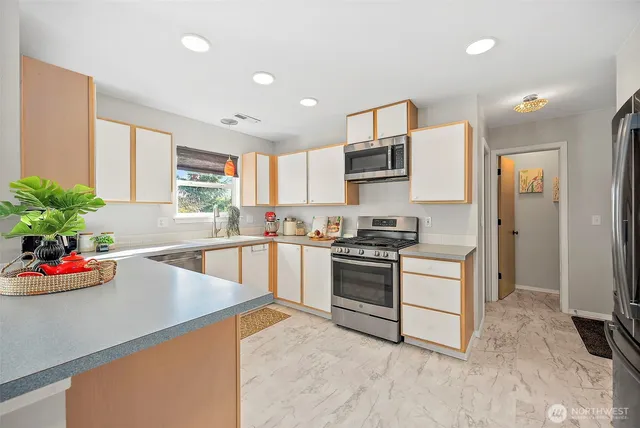 a kitchen with white cabinets and appliances