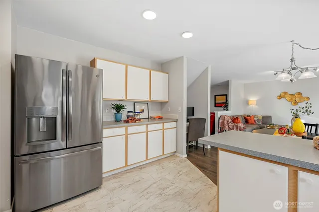 a kitchen with stainless steel appliances a refrigerator sink and white cabinets