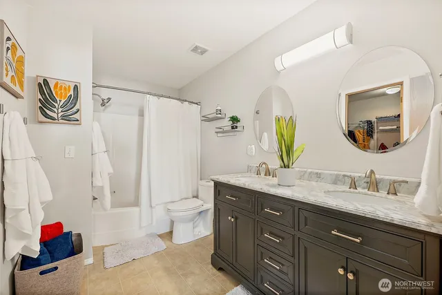 a en suite bathroom with a granite countertop double vanity sink mirror and a
