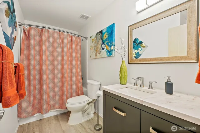 a bathroom with a sink a toilet and a shower curtain