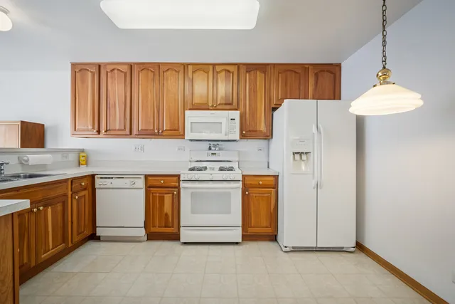 a kitchen with stainless steel appliances granite countertop a refrigerator sink stove and white cabinets