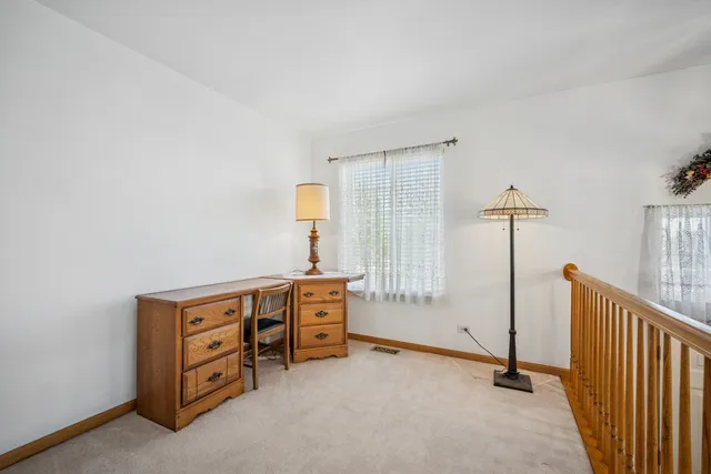 a view of a bedroom with cabinet mirror and windows