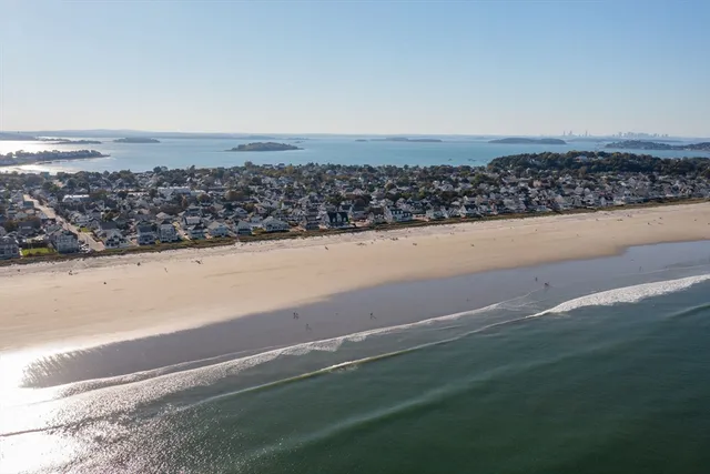 a bathroom with a granite countertop sink a toilet a mirror and a window