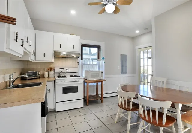 a kitchen with granite countertop a sink stainless steel appliances and white cabinets