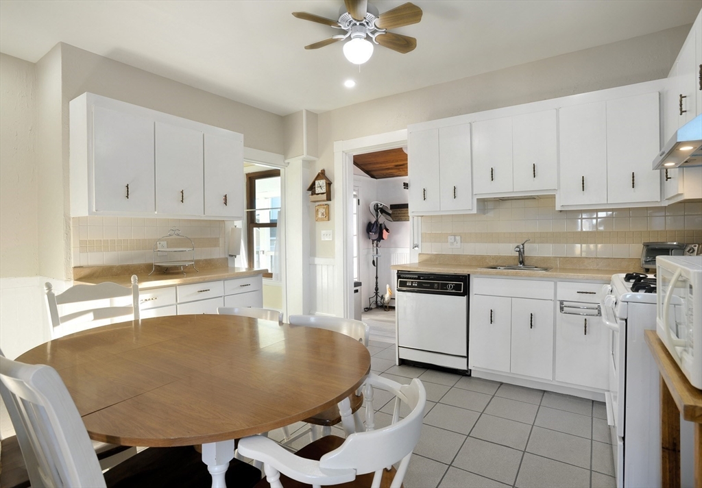 69 Beach Avenue Hull, MA 02045 - Photo 10 of 27 a kitchen with granite countertop a sink stainless steel appliances and white cabinets