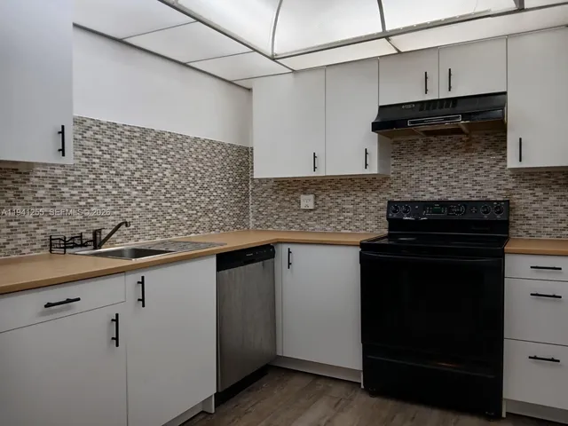 a kitchen with granite countertop cabinets and black stainless steel appliances