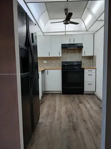 a kitchen with stainless steel appliances granite countertop a refrigerator and a stove top oven