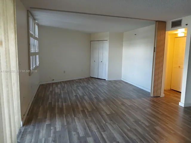 a view of a room with wooden floor and a window