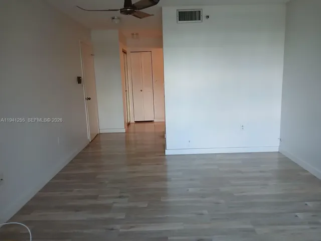 a view of a room with wooden floor