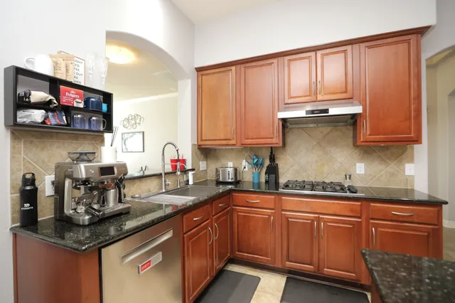 a kitchen with stainless steel appliances granite countertop a sink and cabinets