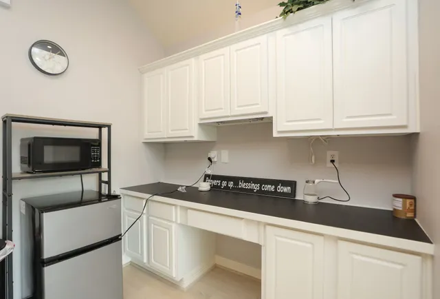 a kitchen with granite countertop white cabinets and a stove top oven