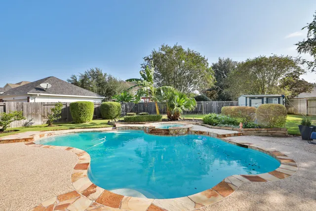 a view of a house with swimming pool and sitting area