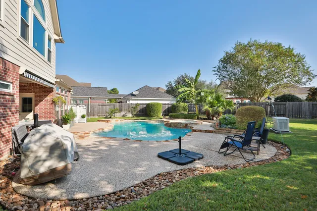 a view of a house with backyard swimming pool and sitting area