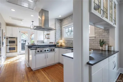 a kitchen with granite countertop a stove and a sink