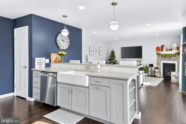 a kitchen with cabinets a sink and a stove with wooden floor