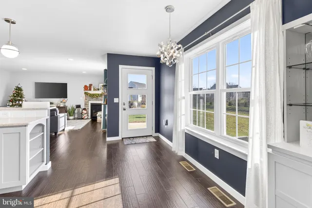 a view of a living room and livingroom with furniture wooden floor fireplace and a chandelier