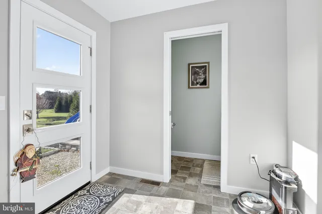 a view of a hallway with wooden floor and a potted plant