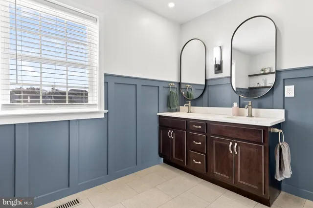 a bathroom with a double vanity sink and a window