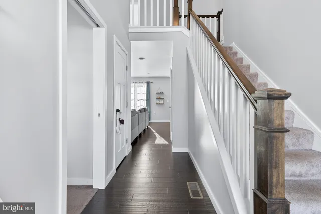 a view of a hallway with wooden floor and staircase