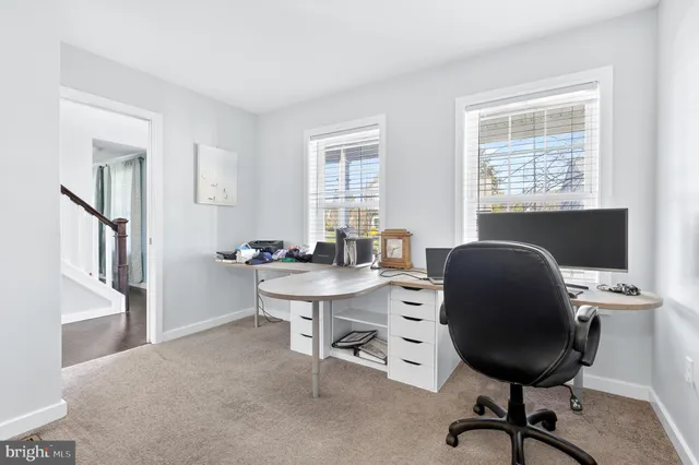 a view of a workspace with furniture and a window