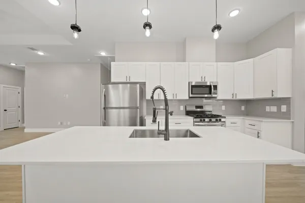 a kitchen with kitchen island a sink stainless steel appliances and cabinets