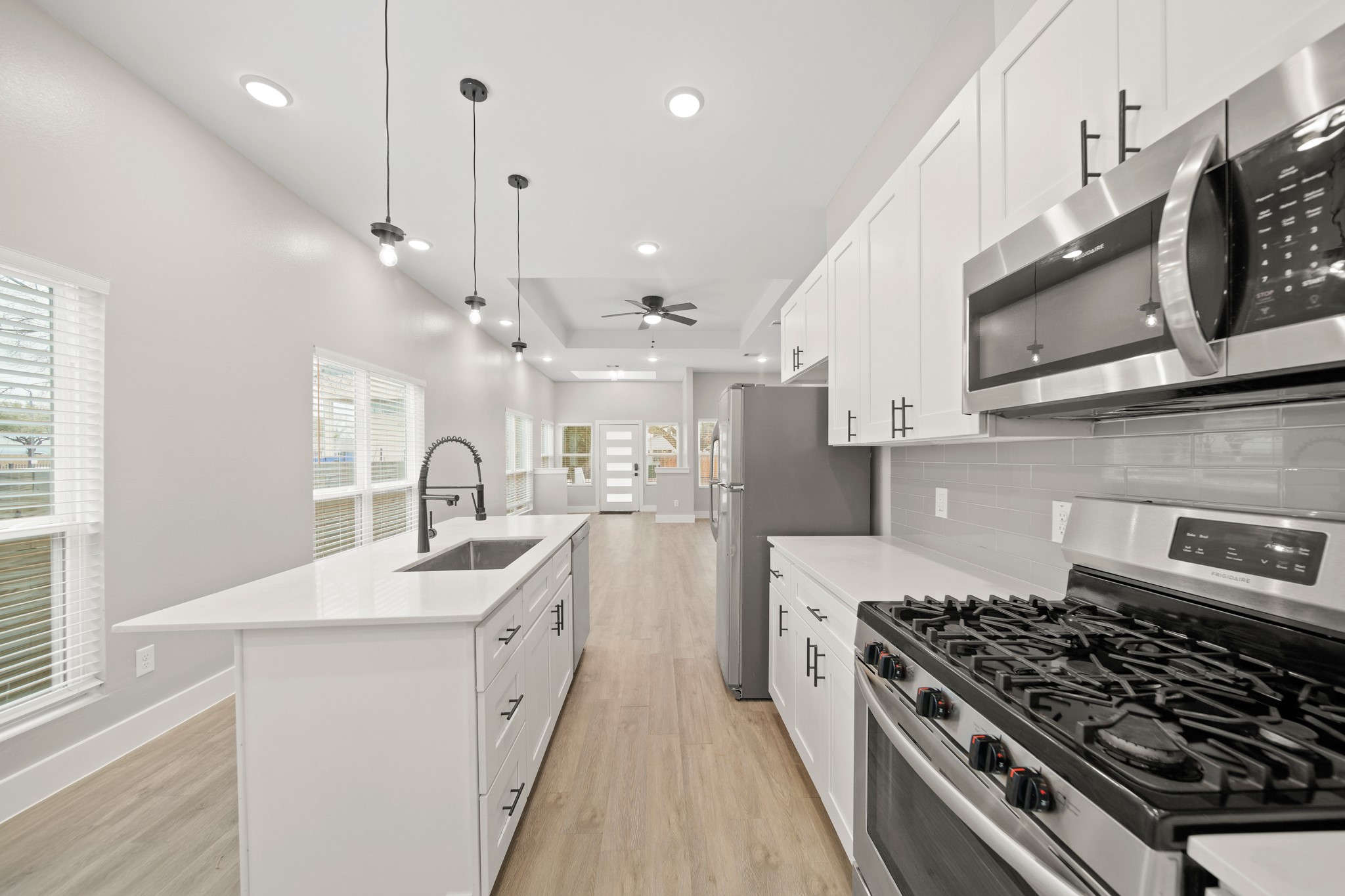 507 Carl Street Houston, TX 77009 - Photo 13 of 25 a kitchen with stainless steel appliances a sink a stove a refrigerator cabinets and a window